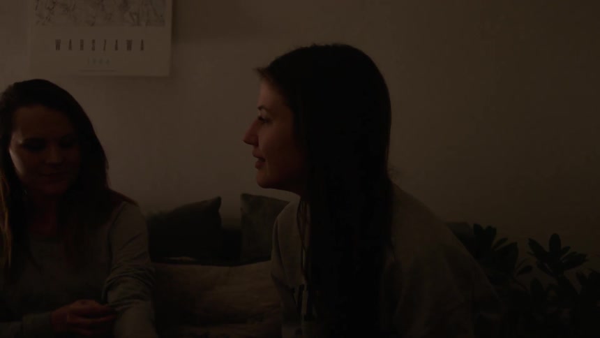 Two women talk in a dark room