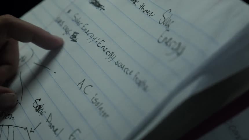 Person points to writing in a notebook