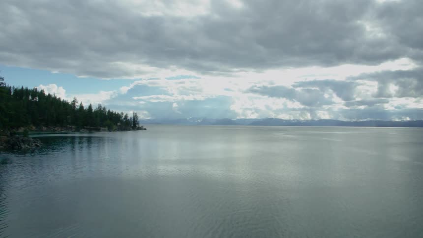 The lake is calm before the forest on the side