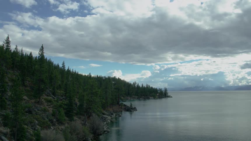 Clouds hang over a coastal area and pine forest