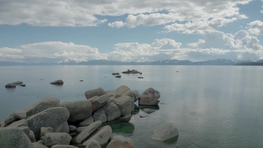 Small granite boulders sit in lake tahoe on a perfectly calm day