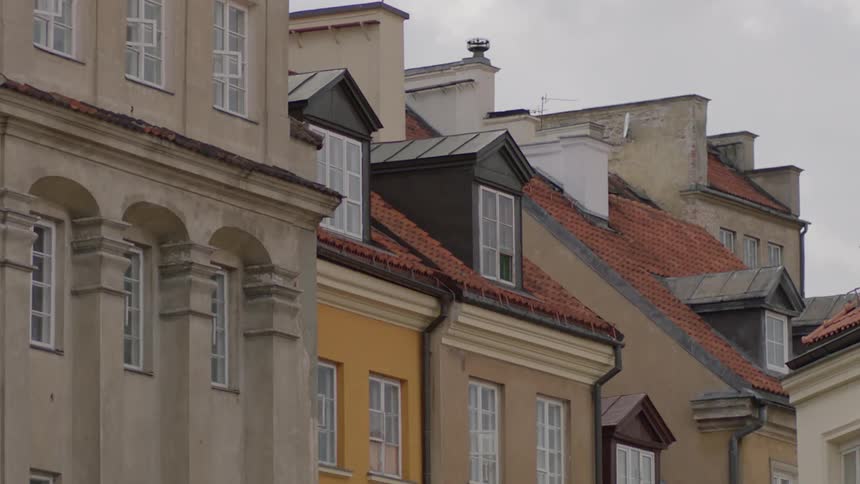 Buildings close together in a city as a bird flies past