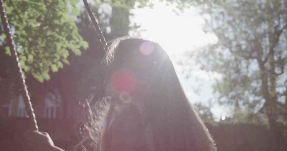A young girl swings on a swing