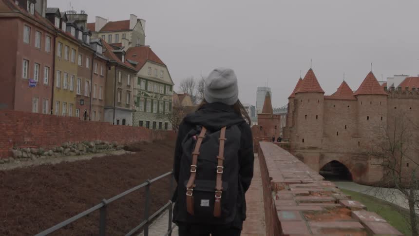 A woman is walking down a trail down a city
