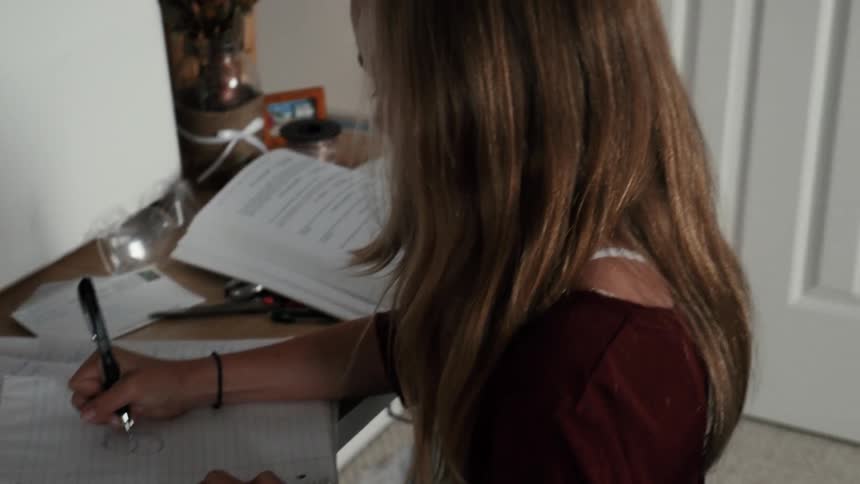 Child writing in a notebook at a desk