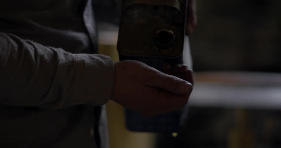 Man pours brown liquid into his hand