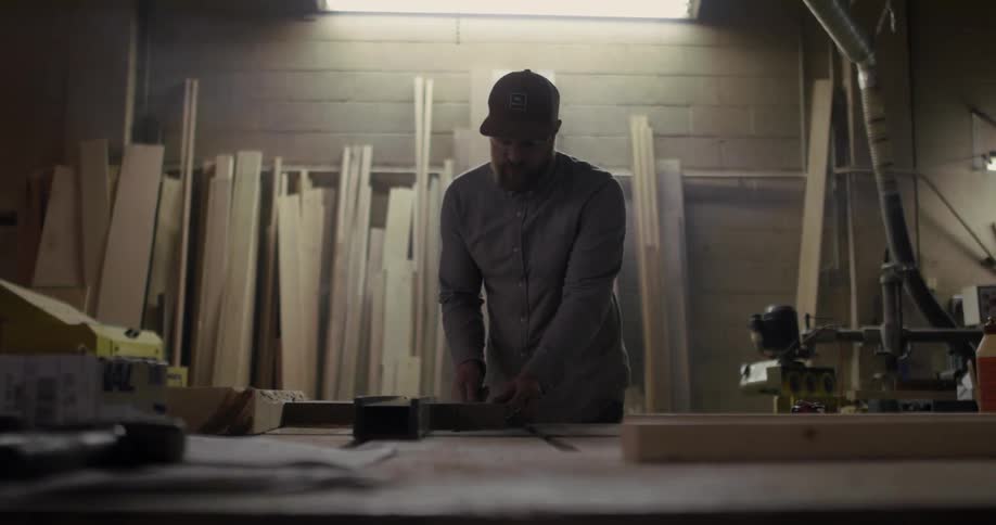 A man saws a plank of wood