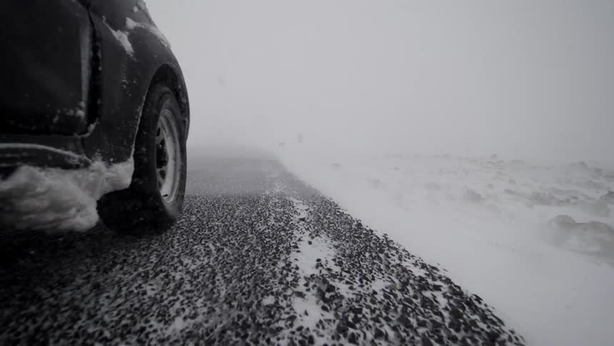 Vehicle drives down a stony snowy road