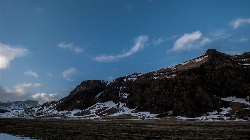Clouds move over a landscape dusted with snow