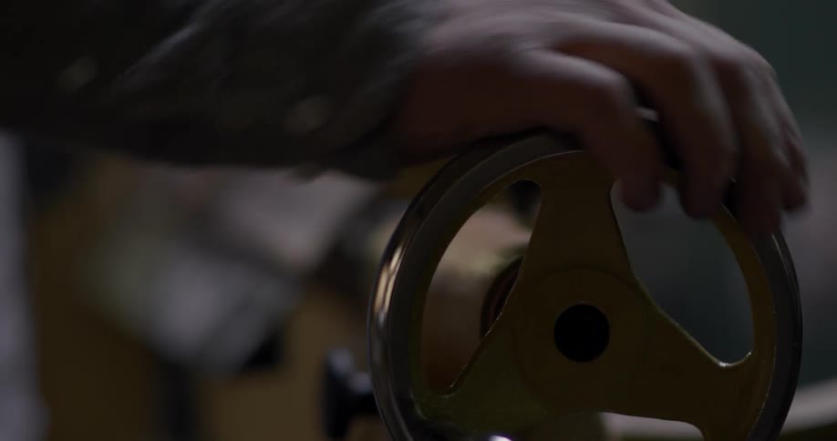 Man turns a wheeled crank