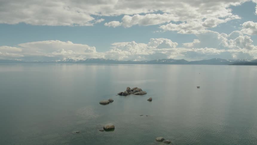 Calm summer lake drone shot in reverse