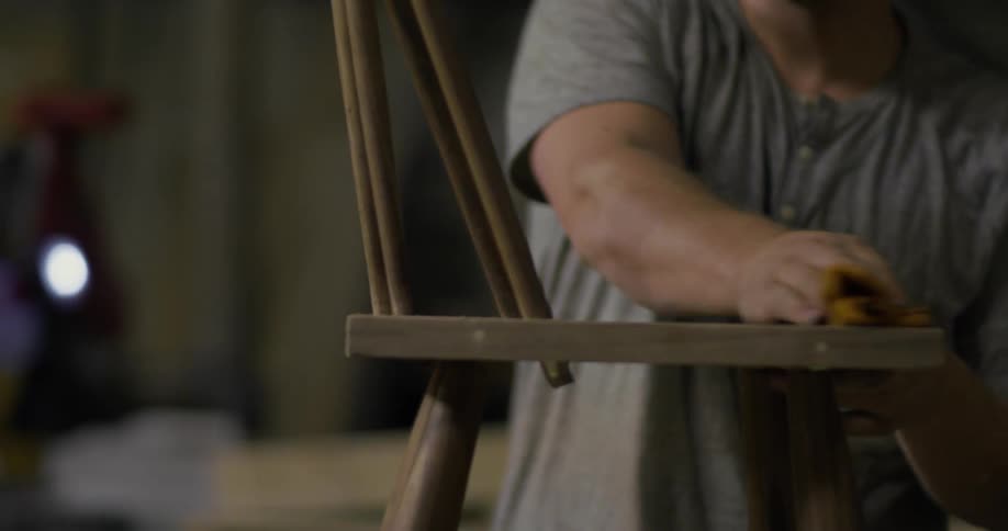 A man is wiping down a new built chair