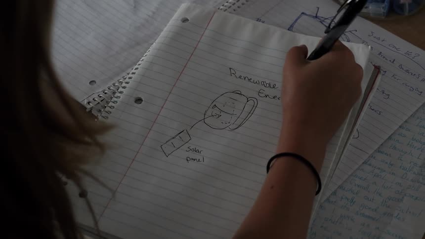 Child draws a picture in a notebook