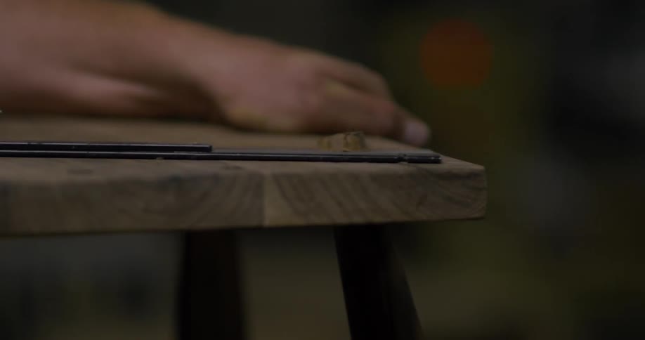 Someone is sanding a bench in a workshop