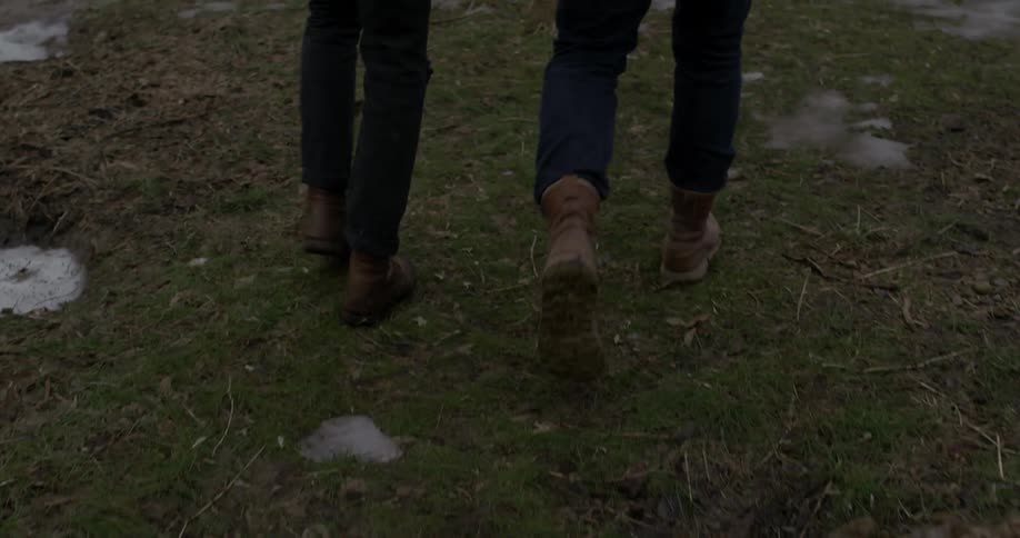 Two people are hiking over a field