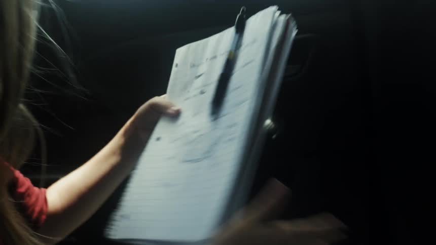 A woman unpacks a notebook from a backpack