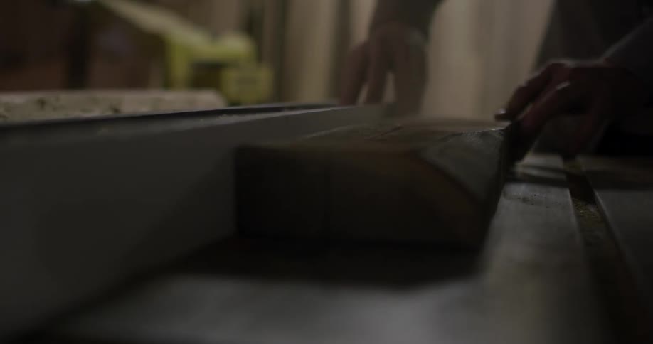 Man using a power saw to cut a piece of wood