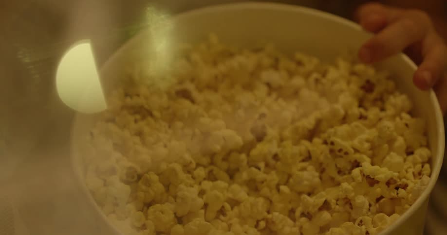 A person eats from a bowl of popcorn