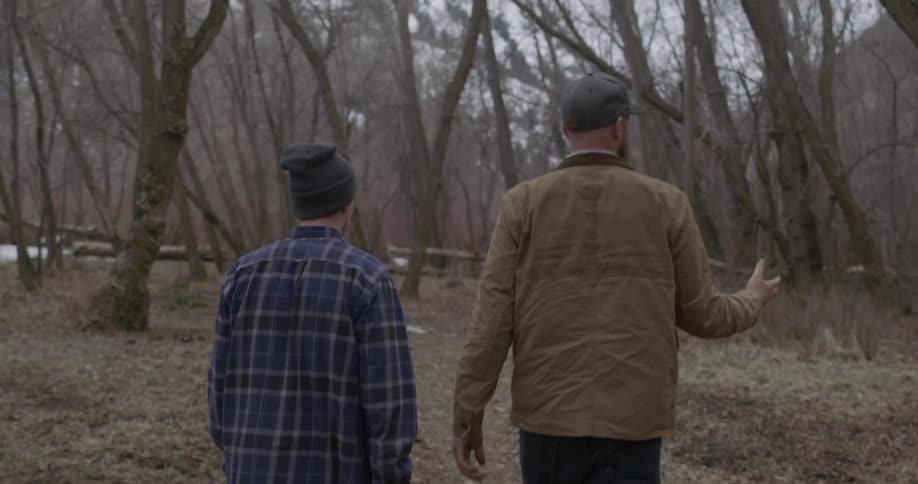 Two men hike in the woods