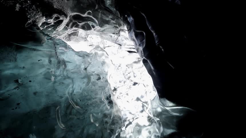 The ice is black and clear with some sun shining in