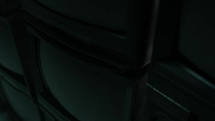 The dark room has some television sets stacked