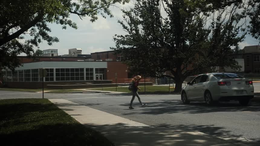 A young girl is picked up at school