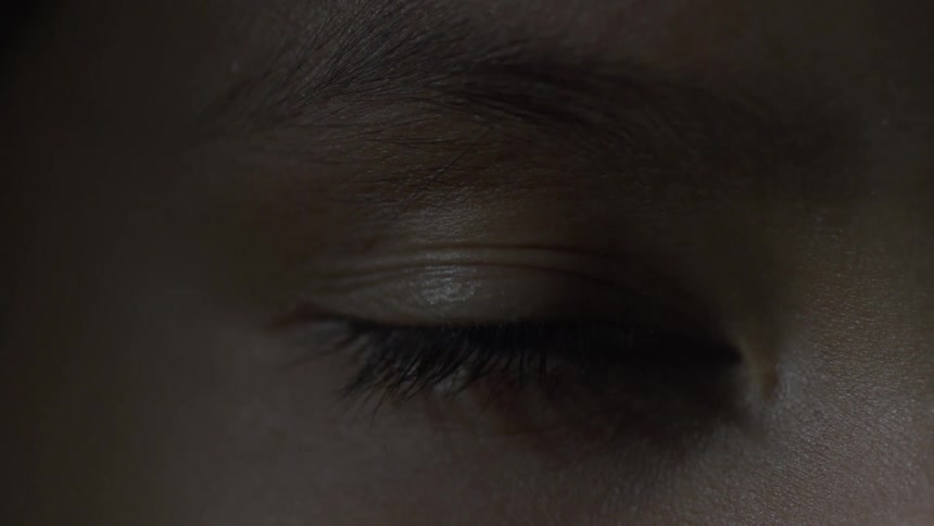 A person slowly opens their eye