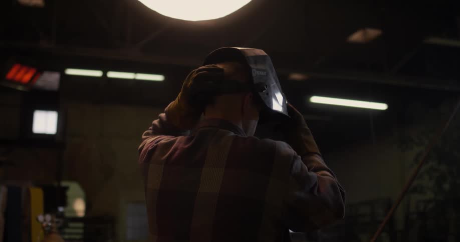 A man puts on his welding mask
