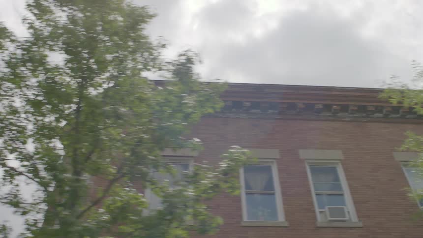 Buildings and trees sit under a cloudy sky