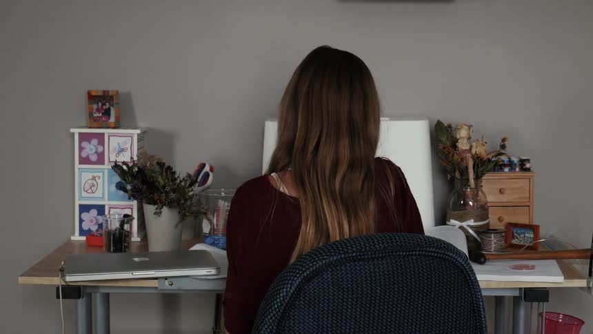 A woman is working at her desk