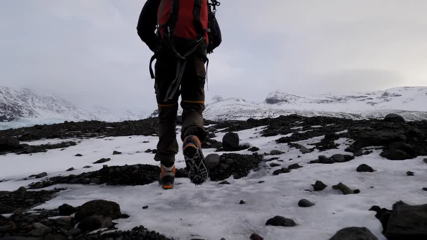A hiker climbs up a snowy mountain