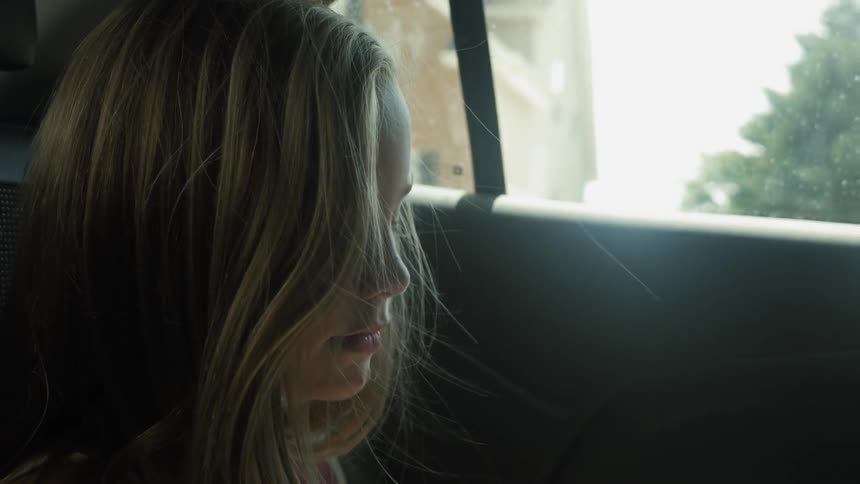 A blond girl rides in the backseat