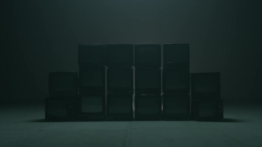 The dark room has a stack of cubes in the middle
