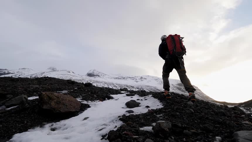 A man is hiking on an ice mountain top