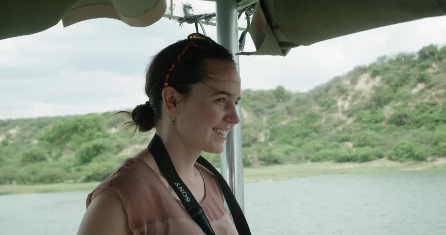 A woman smiles and looks out of a boat