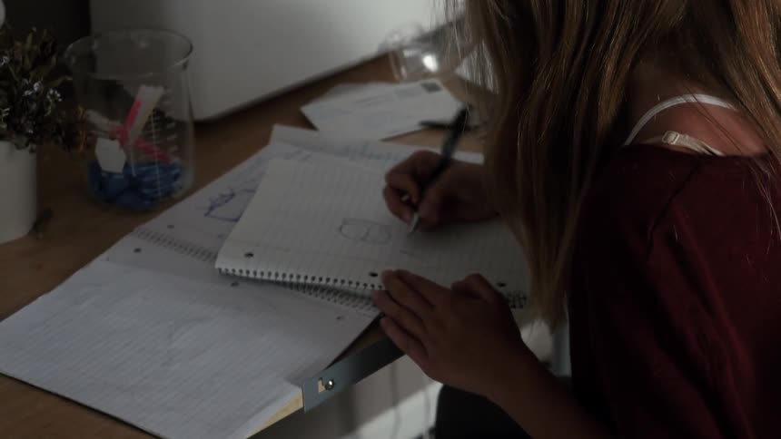 A young girl writes in a notebook