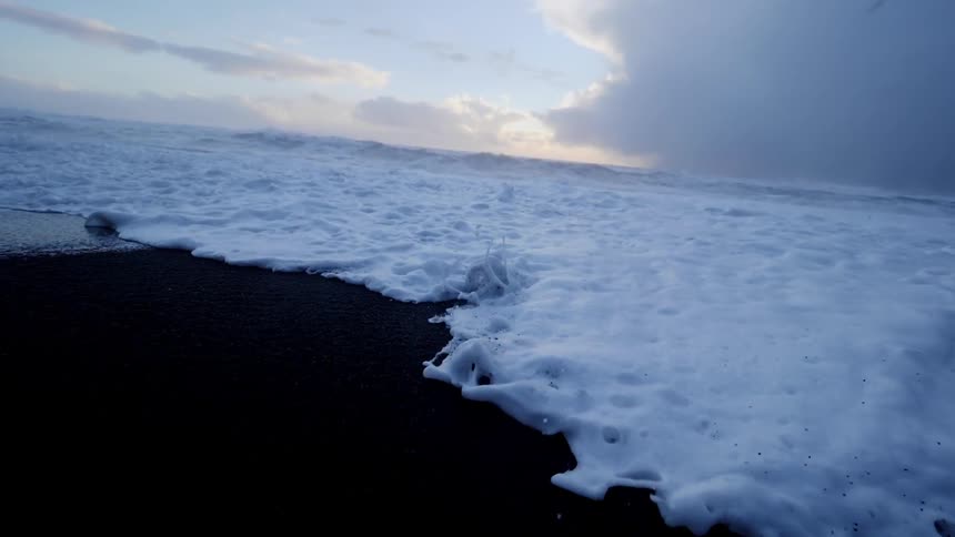 Frothy waves roll in to the shore
