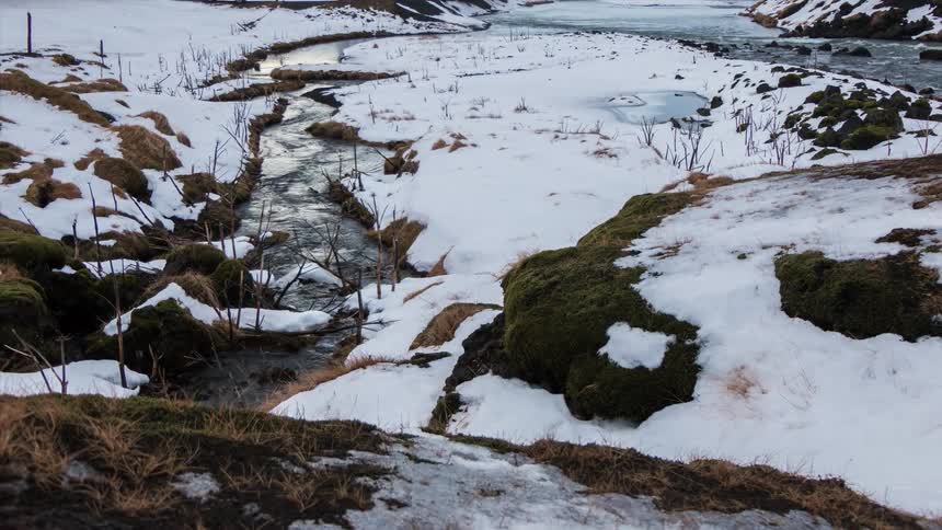 A small brook through a snowy area