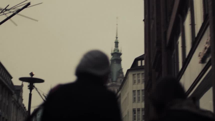 Two girls walk on a city sidewalk