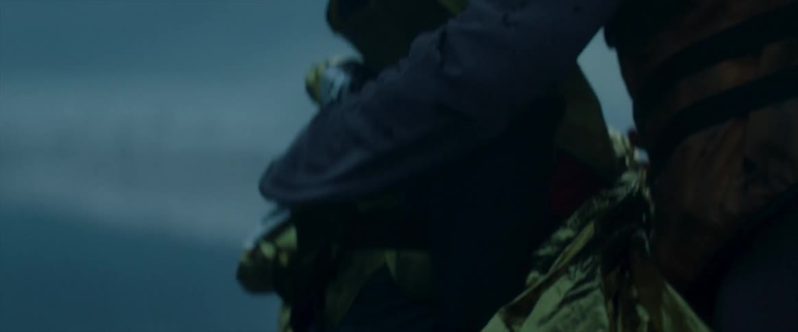 A woman consoles a young boy in the wind on the beach