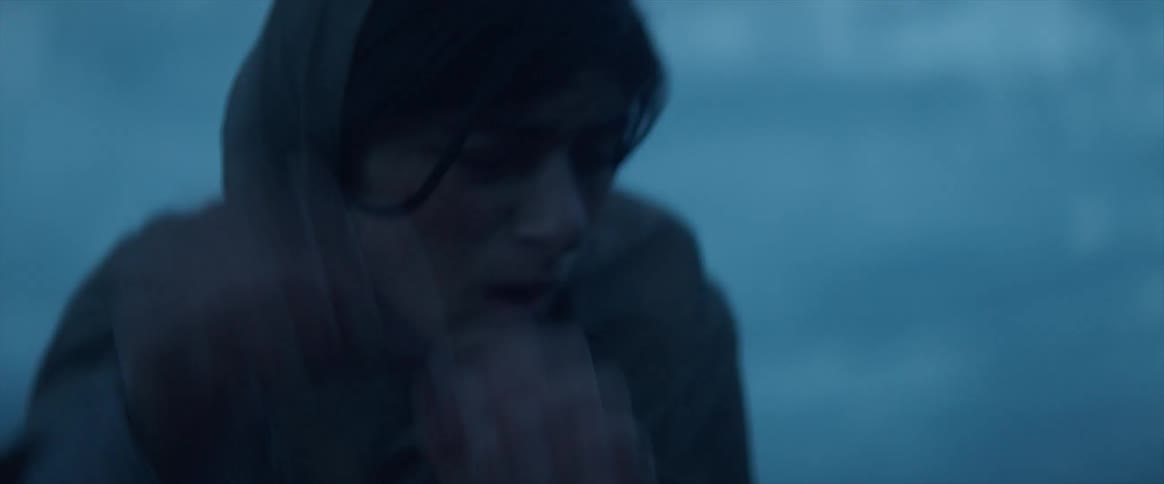A hooded woman shakes something