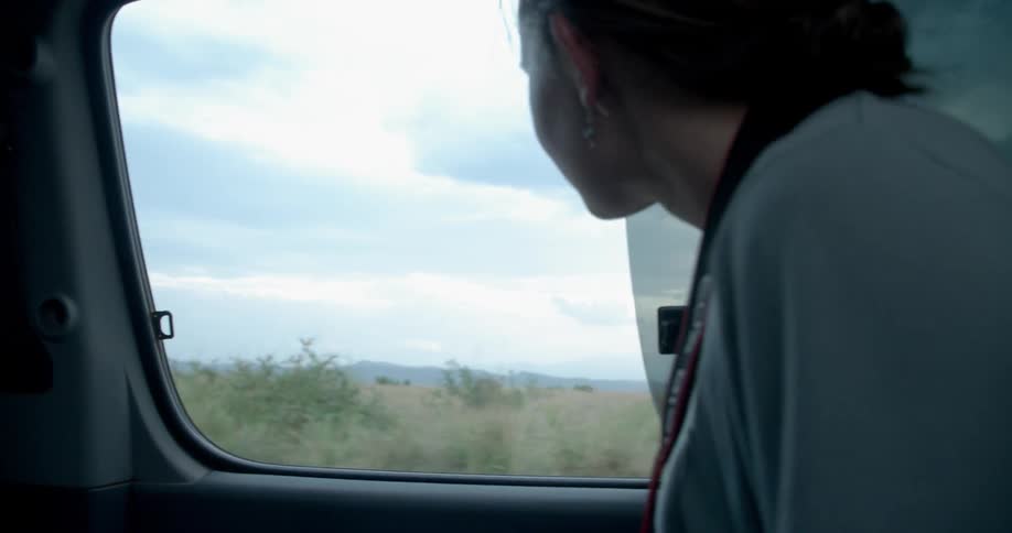 A woman looks out a car window