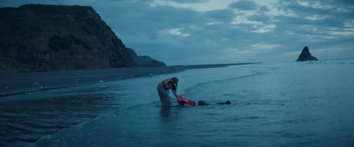 Person dragging a limp body out of water