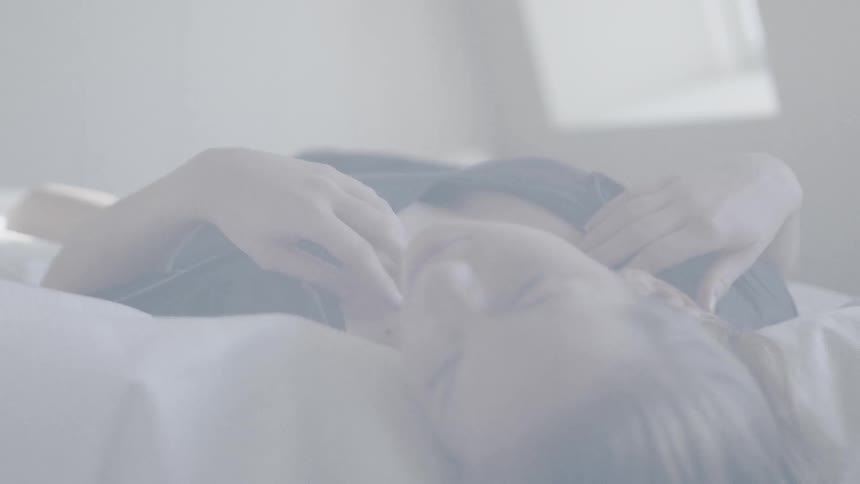 A woman is laying in bed resting