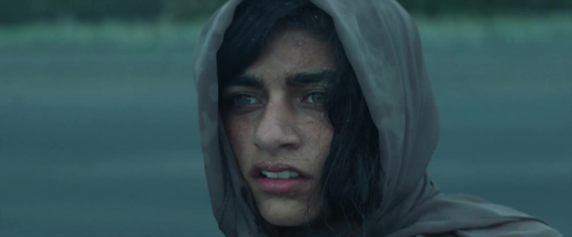 A woman puts on her hood looking worried