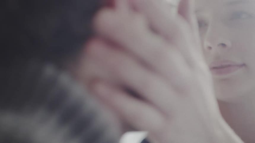 A woman touches a man's face