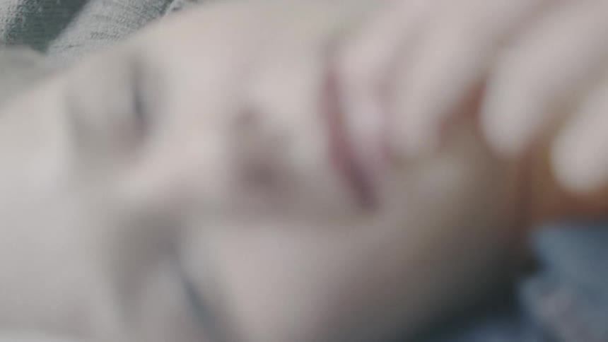 A woman and man lay in a bed back to back