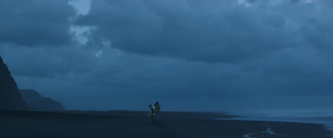 A person is hiking over the beach at dawn