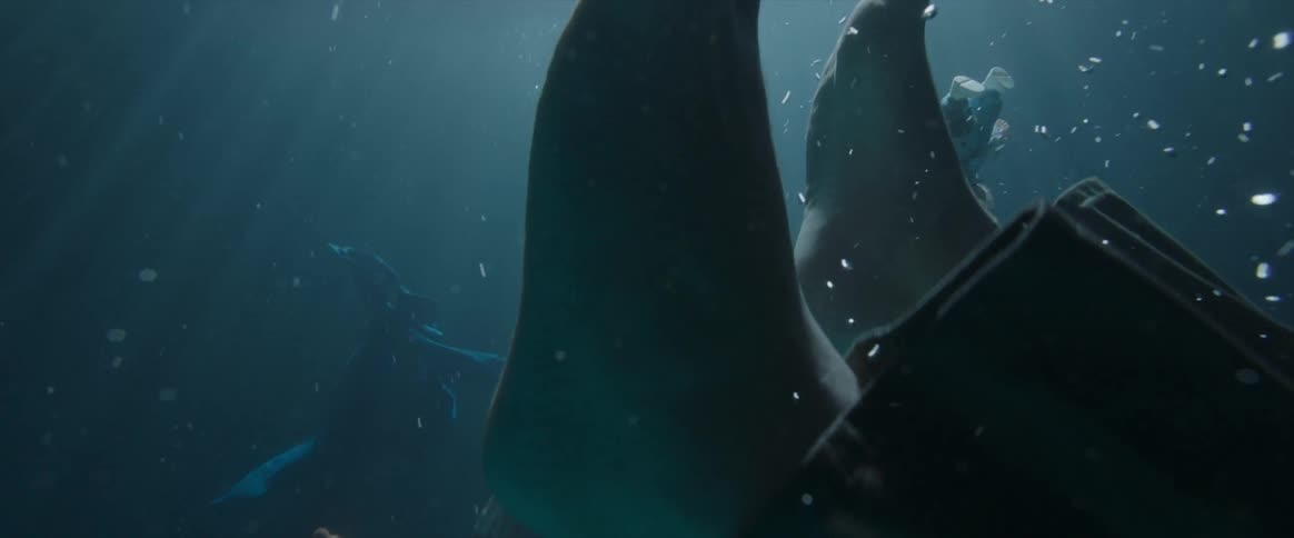 Person with bare feet and a doll sink under the water's surface