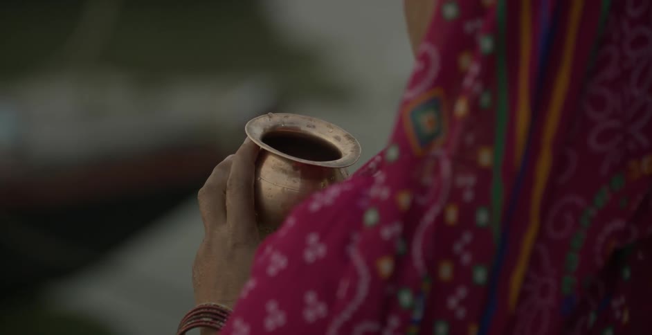 Woman holding a gold goblet in front of her
